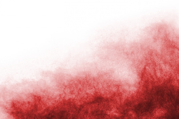 Frieren Sie die Bewegung des roten Pulvers explodieren ein, lokalisiert auf weißem Hintergrund.