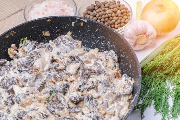 Frigideira com cogumelos fritos morels em molho de creme azedo