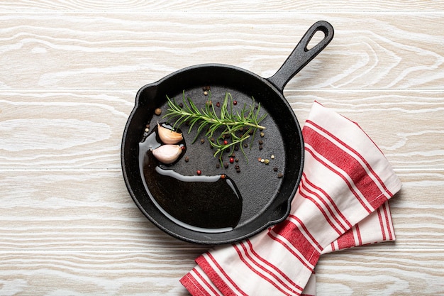 Frigideira de ferro fundido preto com óleo de pimenta e alecrim e alho