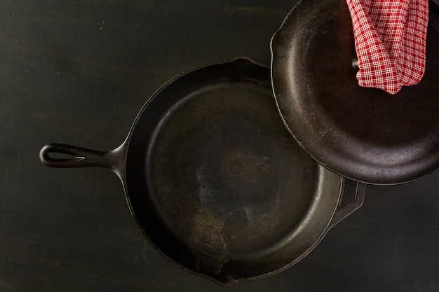 Frigideira de ferro fundido tradicional na mesa de madeira preta.