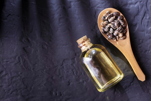 Frijoles y aceite de ricino en la mesa negra