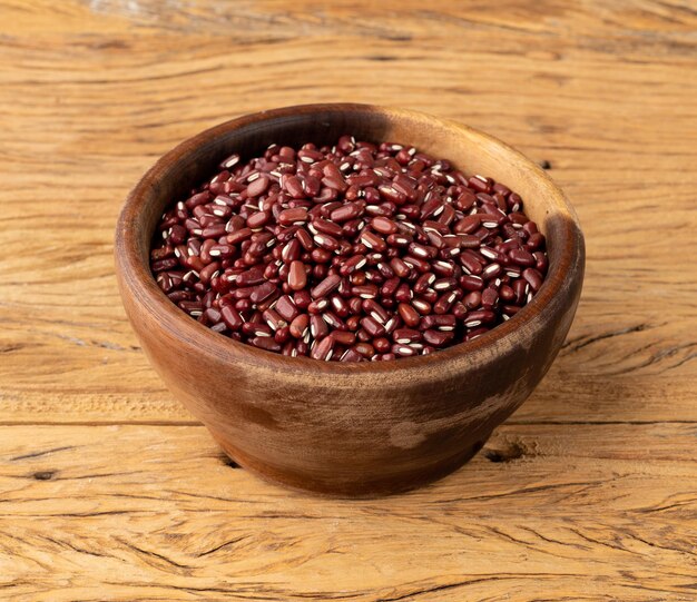 Frijoles Azuki en un recipiente sobre una mesa de madera.