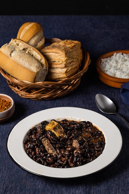 Frijoles y carne de cerdo comida típica brasileña sobre mantel azul oscuro