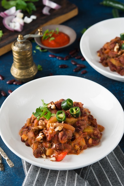 Frijoles estofados tradicionales caucásicos con pimiento y tomate, Lobio. Enfoque selectivo