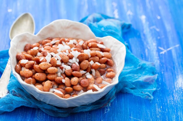 Frijoles hervidos con cebolla en un tazón blanco