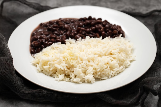 Frijoles negros y arroz hervido en plato blanco