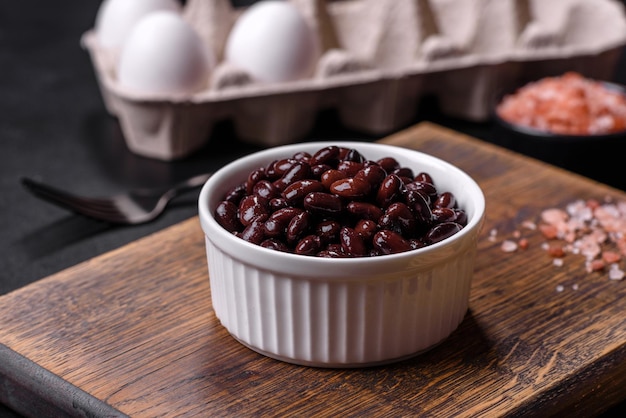 Frijoles negros enlatados en un plato blanco sobre un fondo de hormigón oscuro