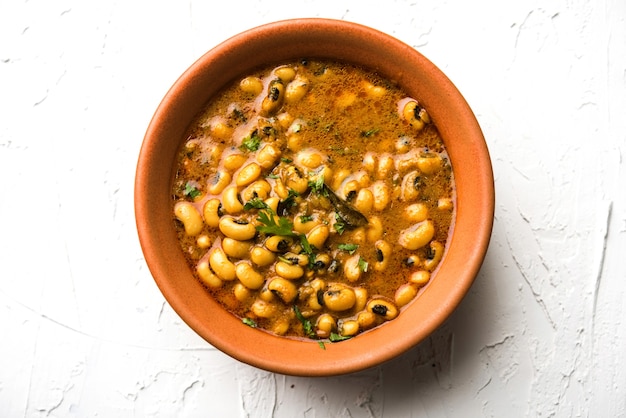 Frijoles de ojos negros al curry o chawli o chavli chi usal o masala, servido en un cuenco de cerámica sobre fondo cambiante, enfoque selectivo