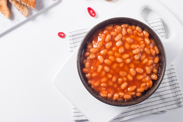 Frijoles picantes sobre fondo de mesa de madera. Frijoles y comida mexicana vegetal.