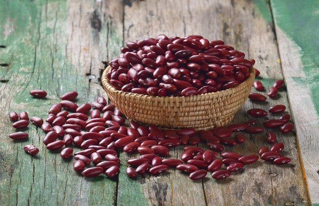 Frijoles rojos en la cesta en madera vieja