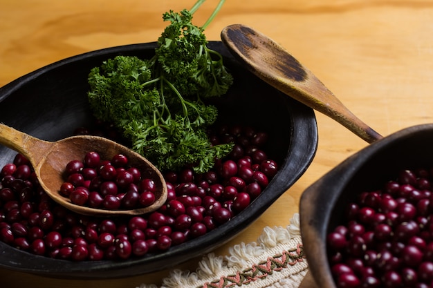 frijoles rojos crudos en platos negros, tabla de cortar y acompañados de perejil