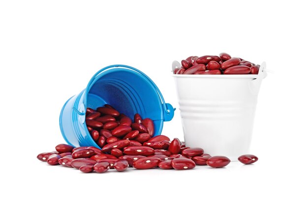 Frijoles rojos en un pequeño cubo azul sobre blanco aislado