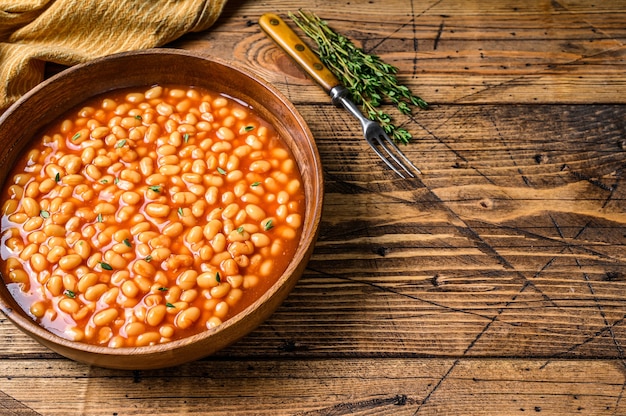 frijoles en salsa de tomate en un plato de madera.