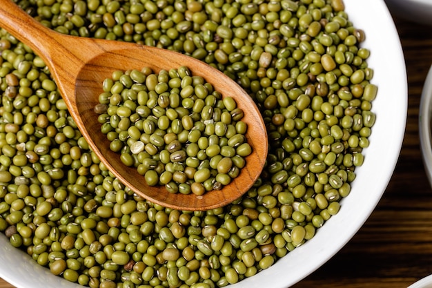 Frijoles secos en cucharas de madera en un tazón