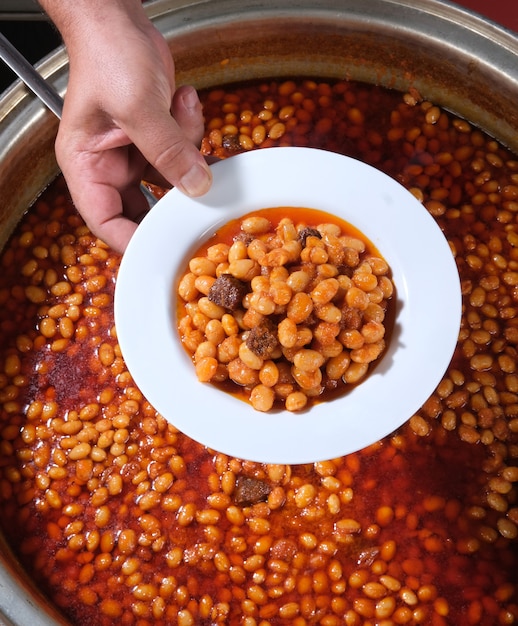 Foto frijoles secos servidos en un plato de una olla recién cocida (kuru fasulye turco)