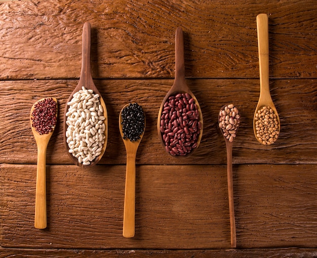 Frijoles surtidos en tazones sobre mesa de madera