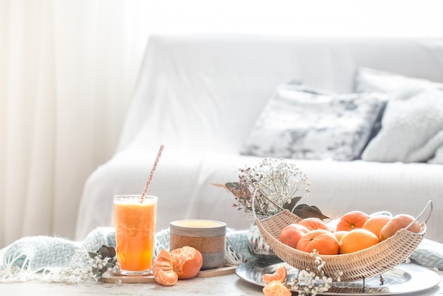 Frisch angebauter frischer Bio-Orangensaft im Inneren des Hauses mit türkisfarbener Decke und Obstkorb