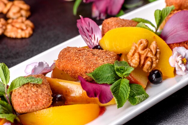 Foto frisch duftende käsesticks mit bratapfel und pfirsich verziert mit blumen auf einem weißen teller