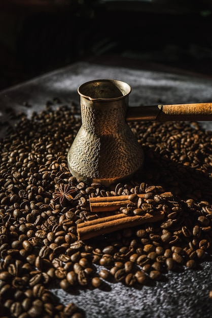 Frisch duftende Röstkaffeebohnen mit Gewürzkaffee in antikem Geschirr 1