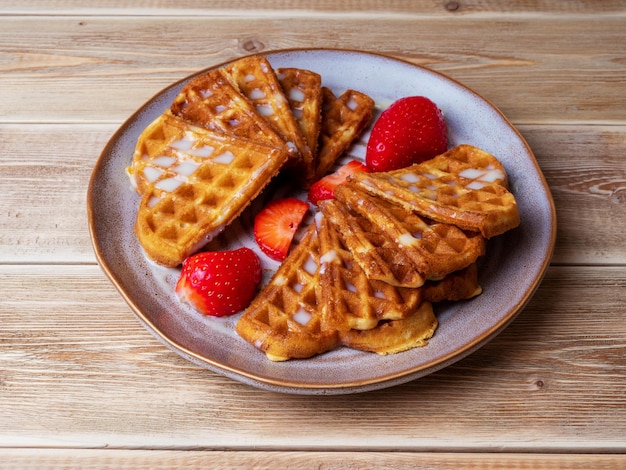 Frisch gebackene belgische Wiener Waffeln bestreut mit Puderzucker mit Erdbeeren