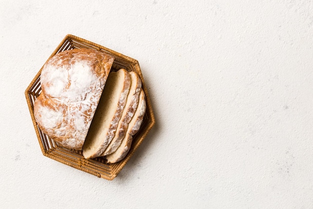 Frisch gebackene Brotscheiben auf Korb gegen Draufsicht des natürlichen Hintergrundes Geschnittenes Brot