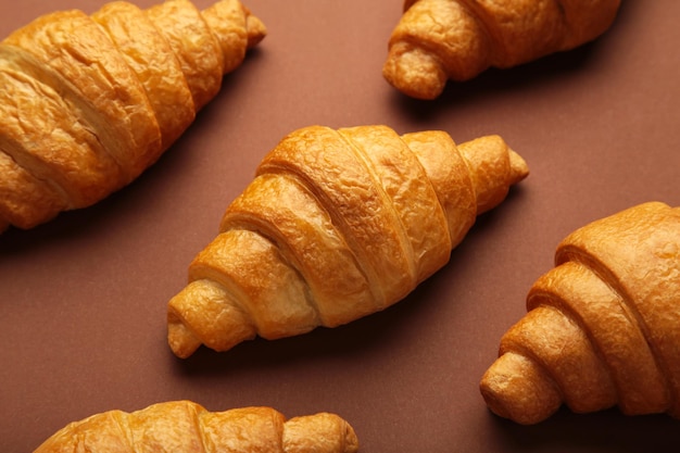 Frisch gebackene Croissants auf braunem Holzhintergrund Warme frische Buttercroissants und Brötchen Französische und amerikanische Croissants und gebackenes Gebäck