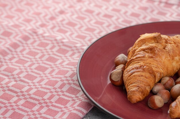 Frisch gebackene Croissants mit gesunden Haselnüssen in der Schale.