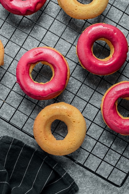 frisch gebackene Donuts mit leuchtend rosa Zuckerguss auf Kühlregal