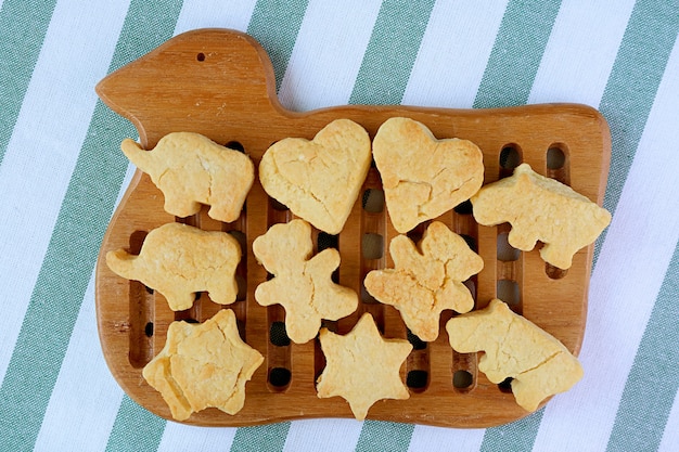 Frisch gebackene hausgemachte, schön geformte Butterkekse, die auf einem hölzernen Entenvogel-Steckbrett gekühlt werden?