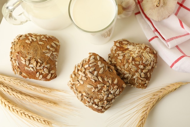 Frisch gebackene Knoblauchbrötchen und Milch auf weißem Tisch