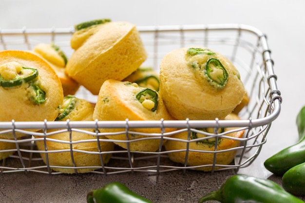 Frisch gebackene Maisbrot-Muffins mit würzigem Jalapeno-Pfeffer im Drahtkorb.