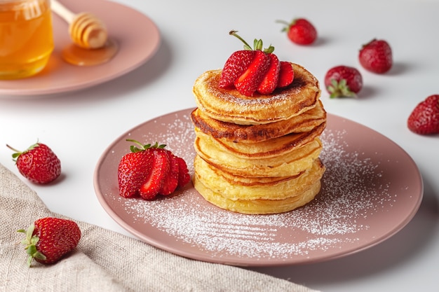 Frisch gebackene Pfannkuchen mit Erdbeeren auf einem natürlichen Holzhintergrund