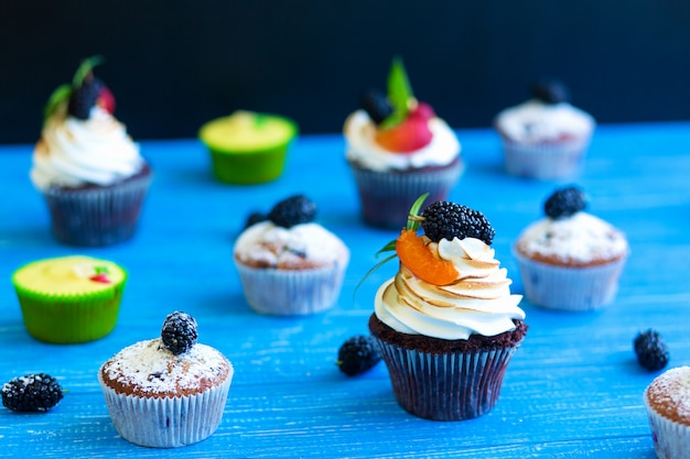 Foto frisch gebackene süße muffins auf blauem grund. süßes gebäck, rezepte, kochen