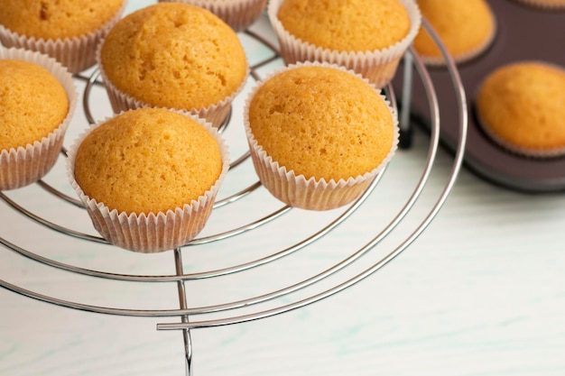 Frisch gebackene Vanille-Cupcakes werden auf ein Kühlregal gelegt