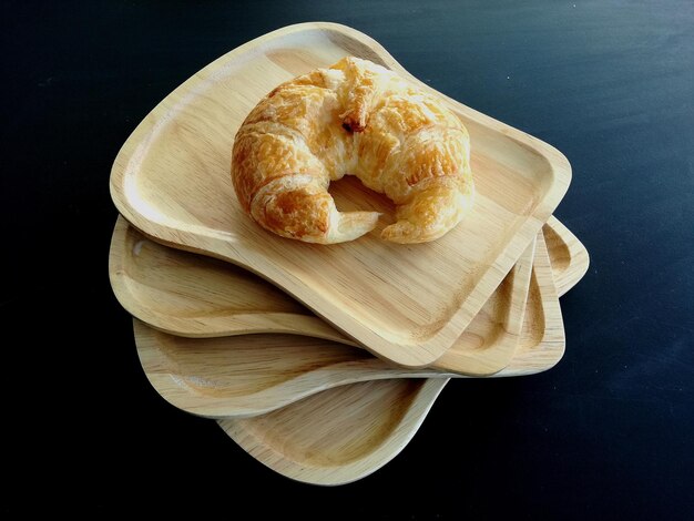 Foto frisch gebackener croissant auf einem holzplattchen