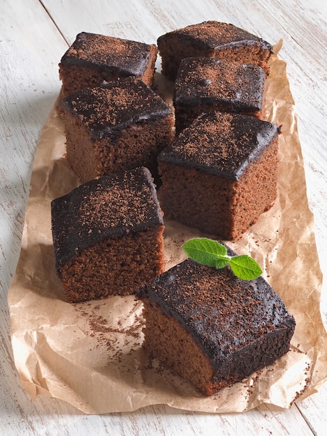 Frisch gebackener klassischer Brownie auf Pergament wird auf einem Whi ausgelegt