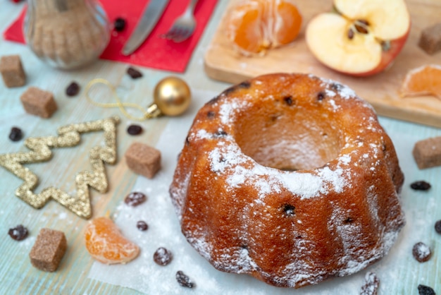 Frisch gebackener köstlicher selbst gemachter Kuchen mit Mandarinen, Rosinen. Weihnachtsdekorationen.