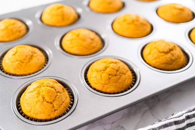 Frisch gebackener Kürbisgewürz-Cupcake, der in einer Cupcake-Pfanne gekühlt wird.