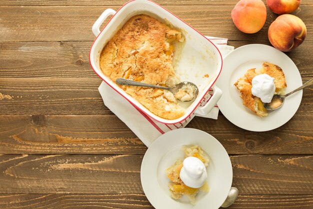 Frisch gebackener Pfirsichschuster mit einer Kugel Schlagsahne.