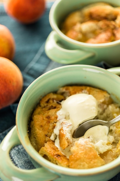 Frisch gebackener Pfirsichschuster mit einer Kugel Vanilleeis.