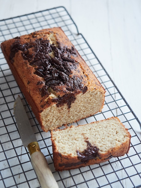 Frisch gebackenes Bananenbrot auf einem Kühlregal mit Schokolade darüber