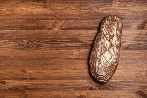 Frisch gebackenes Brot am braunen Holztisch Braunes Grobkornbrot