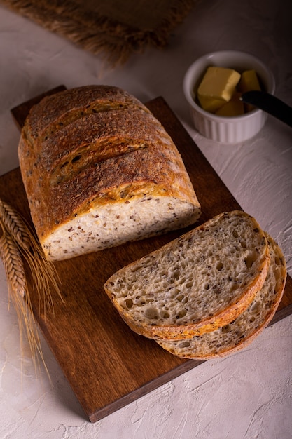 Frisch gebackenes Brot auf einem Holzbrett schneiden