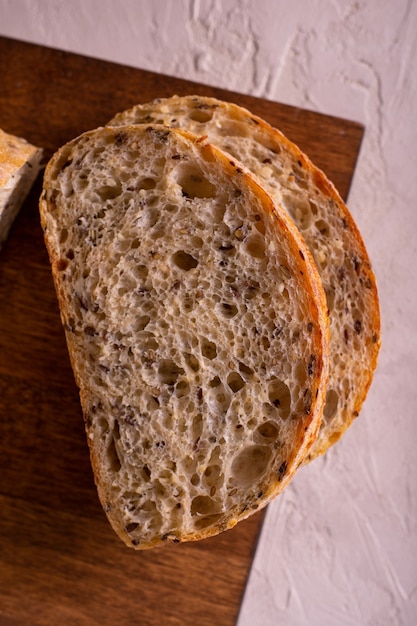 Foto frisch gebackenes brot auf einem holzbrett schneiden