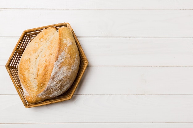 Frisch gebackenes Brot auf Korb gegen Draufsichtbrotkopienraum des natürlichen Hintergrundes