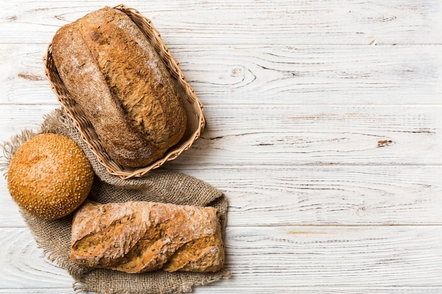 Frisch gebackenes Brot auf Korb gegen Draufsichtbrotkopienraum des natürlichen Hintergrundes