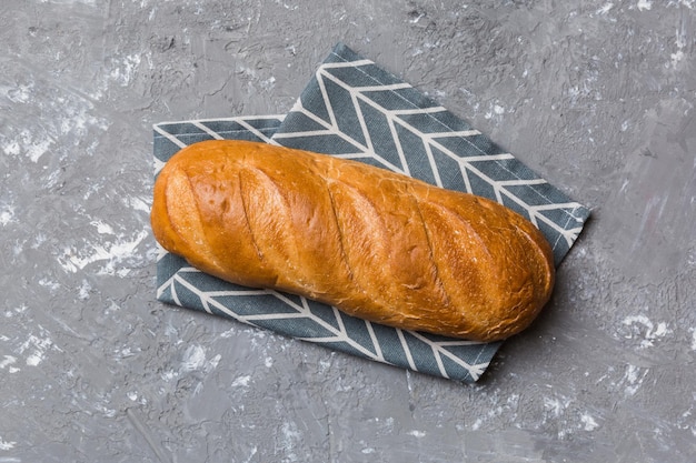 Frisch gebackenes Brot mit Serviette auf rustikalem Tisch Draufsicht Gesundes weißes Brotlaib isoliert