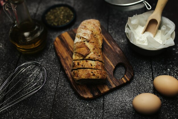 Frisch gebackenes Brot und Backzutaten auf einem Tisch. Hochwertiges Foto