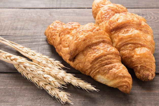 Frisch gebackenes Butterhörnchen auf hölzernem Hintergrund