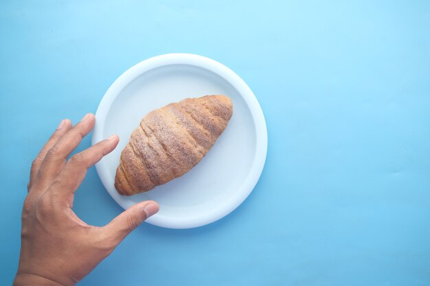 Frisch gebackenes Croissant auf Teller mit Kopierraum